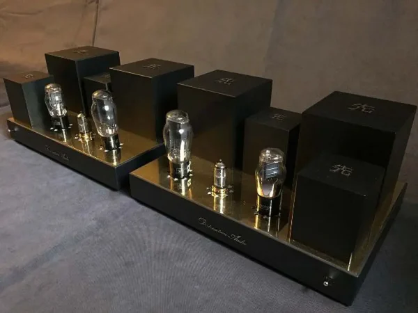 A Vista 3-Way Horn Speakers preamplifier with visible vacuum tubes and sleek black casing, displayed on a gray fabric surface.