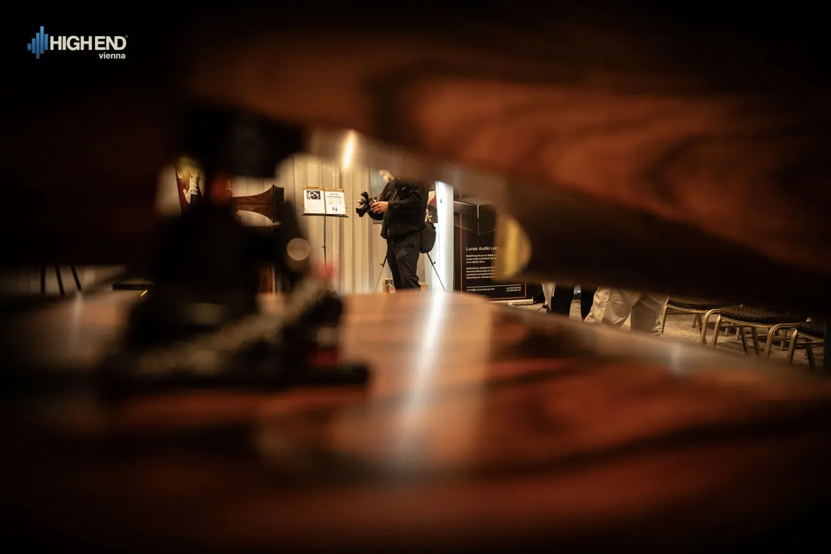 A photographer seen through a gap between wooden parts in the Destination Audio room at High End Vienna