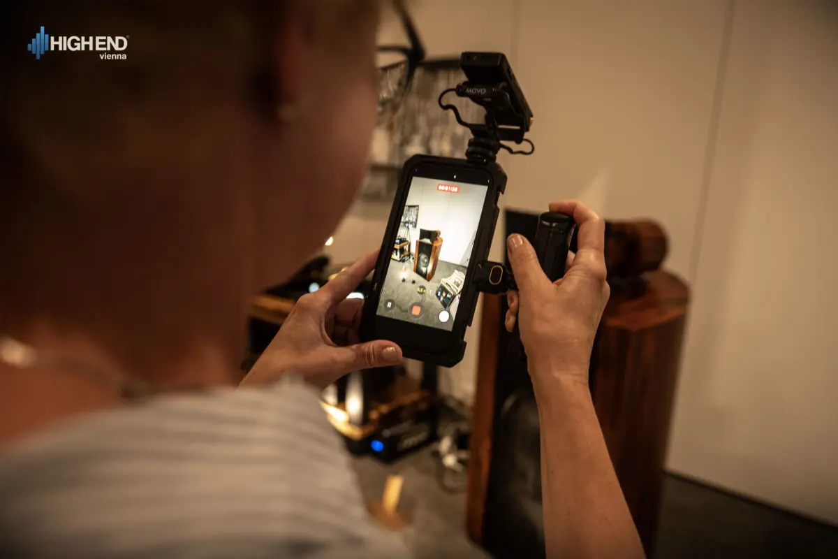 A person filming the Destination Audio room on a phone at High End Vienna