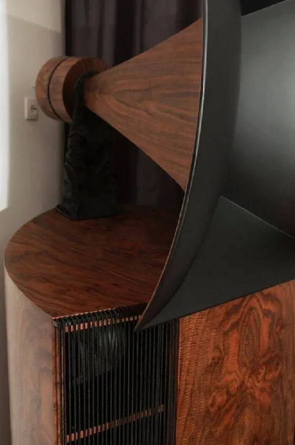 Walnut horn throat leading into the black horn of a Destination Audio Vista speaker, above a ribbed grille